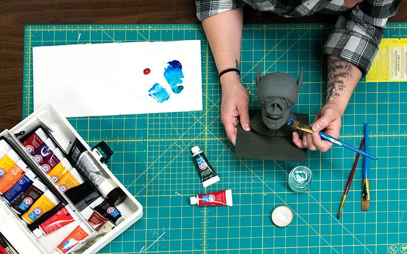 A student sculpts a model to be used in animation.