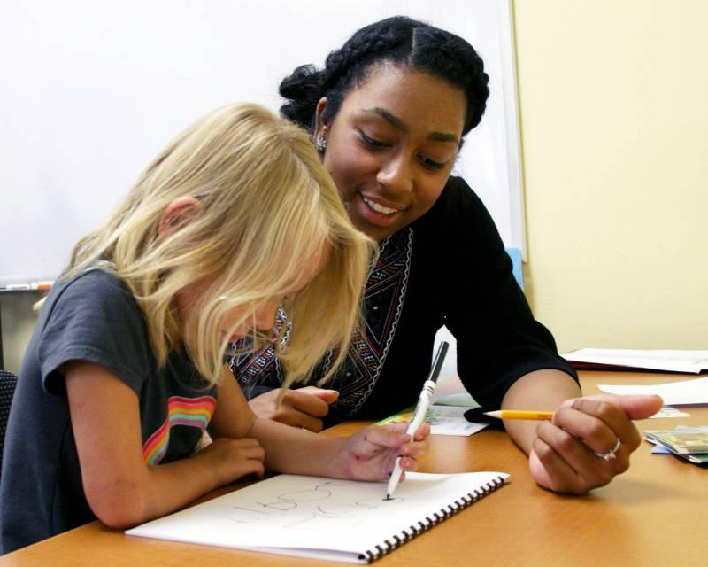 Student teacher helps young child with studies.